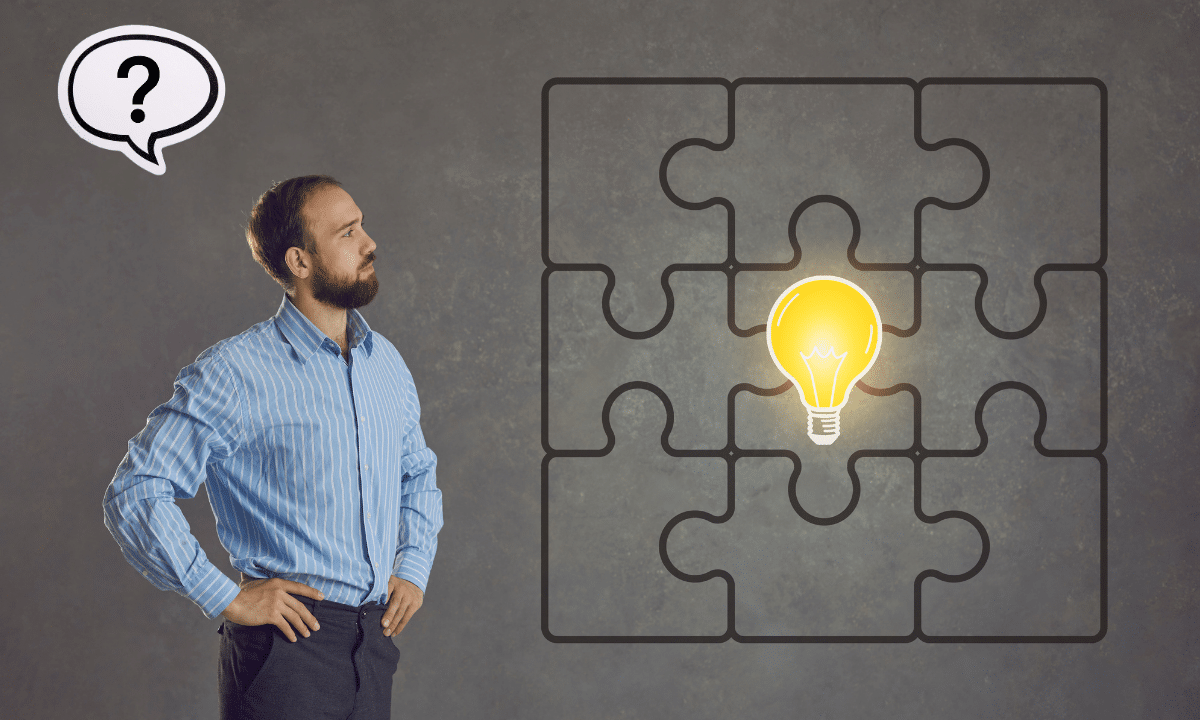 Man staring at the puzzle pieces with a light bulb.